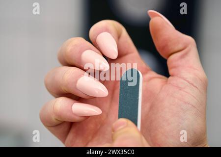Augsburg, Bayern, Deutschland - 21. März 2024: Maniküre Konzept, Eine Frau feilt ihre Fingernägel mit einer Nagelfeile *** Maniküre Konzept, eine Frau feilt mit einer Nagelfeile die Fingernägel Stockfoto