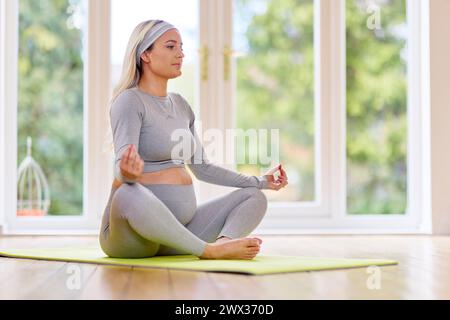 Schwangere Frau, die Yoga macht Stockfoto