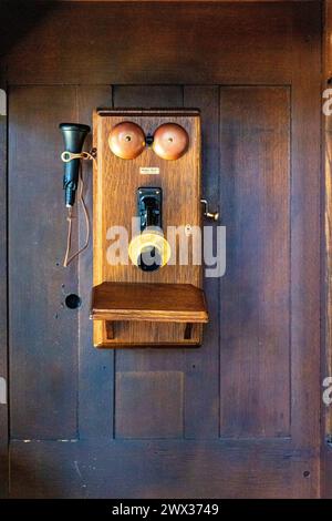 Altes Telefon an der Wand mit Kurbel. Stockfoto