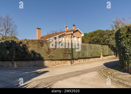 Eine Urbanisierung von Wohnhäusern in einem Berggebiet mit großen Hecken im Umzäunungsgebiet Stockfoto