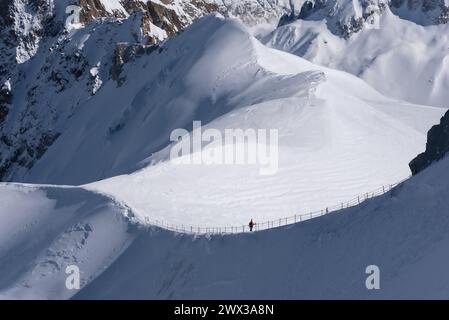 Ein einzelner Skifahrer in Silhouette steht auf dem Kamm, der von der Aiguille du Midi zum Vallee Blanche im Mont Blanc-Massiv in Chamonix in Fra führt Stockfoto