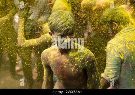 Nachtschwärmer tanzen im Takt der Musik, während sie Holi auf einer Straße feiern, das hinduistische Frühlingsfest der Farben am 25. März 2024 in Guwahati, Assam Stockfoto