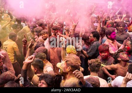 Nachtschwärmer tanzen im Takt der Musik, während sie Holi auf einer Straße feiern, das hinduistische Frühlingsfest der Farben am 25. März 2024 in Guwahati, Assam Stockfoto