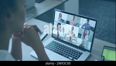 Bild der Weltkarte und Symbole über afroamerikanischer Frau, die ein Bild auf einem Laptop abruft. Unternehmen, Finanzen, Wirtschaft und Technologie Konzept digital Gen Stockfoto