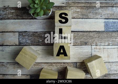 Konzept der Wooden Cubes mit dem Wort SLA - Service Level Agreement auf hölzernem Hintergrund. Stockfoto