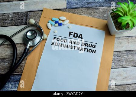 Konzept der FDA - Food and Drug Administration Schreiben auf Papiere isoliert auf hölzernem Hintergrund. Stockfoto