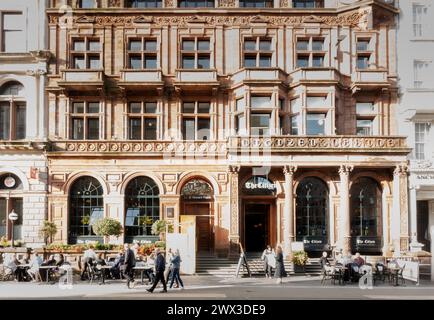 Menschen in bunten Sommerküchern genießen einen Drink in der Sonne auf der Terrasse des Citizen Restaurants Glasgow, Schottland, Großbritannien Stockfoto