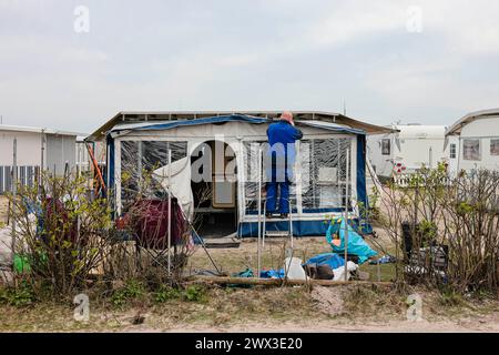 Damp, Deutschland. März 2024. Ein Mann arbeitet an einer Markise auf dem Campingplatz Ostseecamping in Schubystrand. Pünktlich zu Ostern kommen die ersten Gäste der Saison auf den Campingplätzen an Nord- und Ostsee und im Landesinneren Schleswig-Holsteins an. Frank Molter/dpa/Alamy Live News Stockfoto