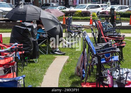 Suwanee, GA / USA - 12. August 2023: Zwei Menschen schützen die sengende Hitze mit Regenschirmen, während sie auf ein Sommerkonzert warten. Stockfoto