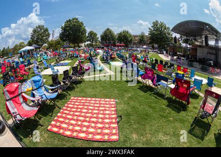 Suwanee, GA / USA - 12. August 2023: Dutzende leere Rasenstühle werden für ein Sommerkonzert im Suwanee Town Park Amphitheater aufgestellt. Stockfoto