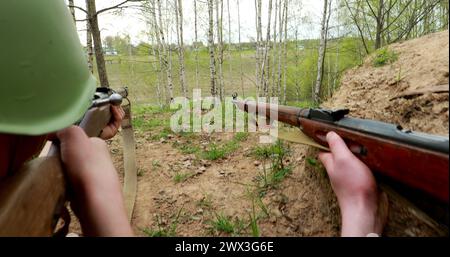 Als sowjetischer russischer Soldat gekleidet, der mit Gewehren zielt. Soldaten Schießen Mit Gewehr. Sowjetische Russische Soldatenuniform Stockfoto