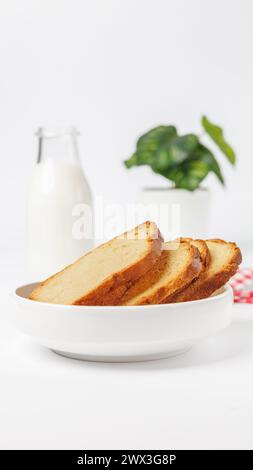 Brotscheiben auf einem weißen Teller mit Milch auf weißem Hintergrund Stockfoto