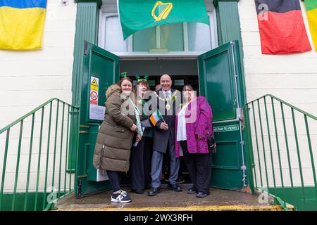 Der Bürgermeister von Warrington Cllr Stever Wright und seine Frau schwenken mit Kollegen am Eingang zum Irish Club seine irische Flagge Stockfoto