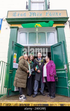 Der Bürgermeister von Warrington Cllr Stever Wright und seine Frau schwenken mit Kollegen am Eingang zum Irish Club seine irische Flagge Stockfoto