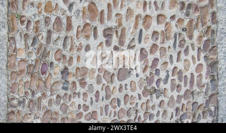 Kopfsteinpflaster aus kleinen Kieselsteinen. Monumentale komplexe Straßenoberflächen, Caceres, Spanien Stockfoto