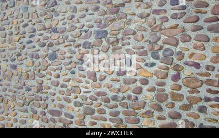 Kopfsteinpflaster aus kleinen Kieselsteinen. Monumentale komplexe Straßenoberflächen, Caceres, Spanien Stockfoto