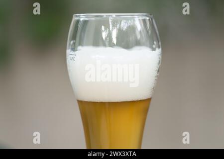 Schäumendes Bier in einem Bierglas. Der Hintergrund ist unscharf. Nahaufnahme. Stockfoto