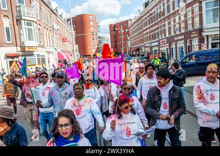 25. März in den Haag. Millionen von Menschen weltweit feiern das jährliche Holi Hangámá Festival, auch bekannt als das Festival der Farben, was bedeutet, die Ankunft des Frühlings zu feiern. In den Haag, wo die größte indische Bevölkerung Europas zu finden ist, fand eine große Feier im multikulturellen Viertel Transvaal statt, wo die Teilnehmer buntes Pulver auf sich und einander warfen. Die Leute feierten dieses Ereignis, indem sie in einer farbenfrohen Prozession durch die Nachbarschaft gingen und sangen und tanzten. Stockfoto