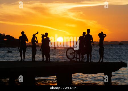 Salvador, Bahia, Brasilien - 09. März 2019: Jugendliche in Silhouette werden zusammen gesehen und genießen den Sonnenuntergang von der Spitze der Crush Bridge in der Stockfoto