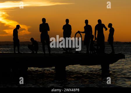 Salvador, Bahia, Brasilien - 09. März 2019: Jugendliche in Silhouette werden zusammen gesehen und genießen den Sonnenuntergang von der Spitze der Crush Bridge in der Stockfoto