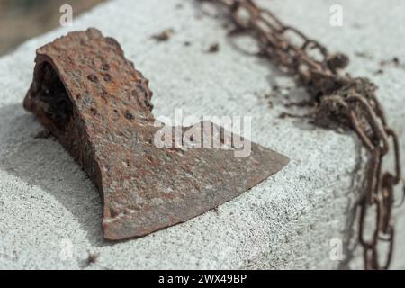 Abstract von Holzwerkzeugen mit gebrochener rostiger Axt, Kopf, Kette auf einem Gassilikatblock Stockfoto