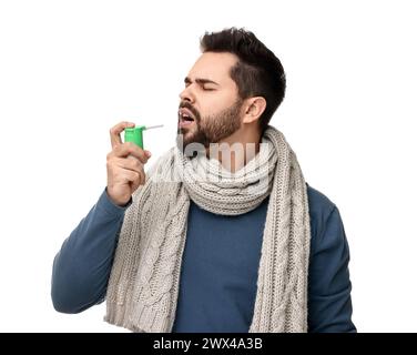 Junger Mann mit Schal mit Kehlspray auf weißem Hintergrund Stockfoto