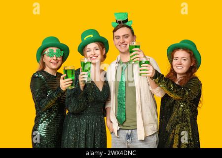 Gruppe von Leuten mit Bier auf gelbem Hintergrund. St. Patrick's Day-Feier Stockfoto