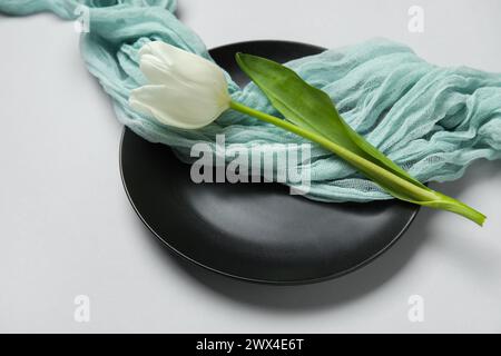 Schöne Tischdekoration mit weißer Tulpe auf grauem Hintergrund Stockfoto