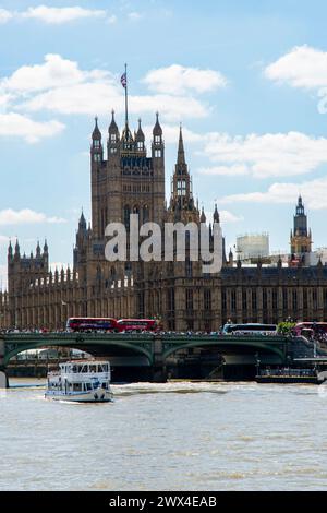 Londons berühmte Houses of Parliament und Big Ben überragen an einem hellen, sonnigen Tag die geschäftige Themse. Stockfoto