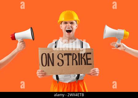 Protest gegen die Feuerwehr mit Plakat mit STREIKTEXT und Megaphonen vor orangem Hintergrund Stockfoto