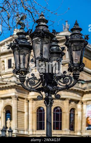 Vor einem großen Gebäude steht ein kunstvoller schwarzer Lampenpfosten Stockfoto