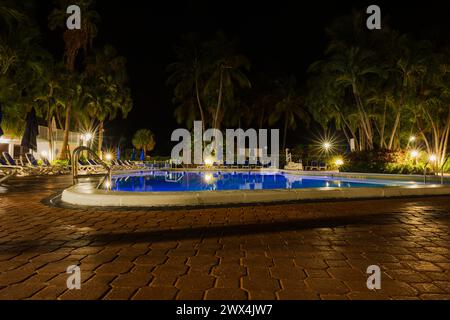 Das Radisson Hotel ist umgeben von einer wunderschönen nächtlichen Atmosphäre, wo Palmen neben einem beleuchteten Außenpool schwingen. Miami Beach. USA. Stockfoto