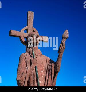 Blick auf die Statue von Saint Aidan vor einem blauen Himmel auf der Heiligen Insel lindisfarne in der Nähe von Berwick-upon-Tweed in Northumberland Stockfoto