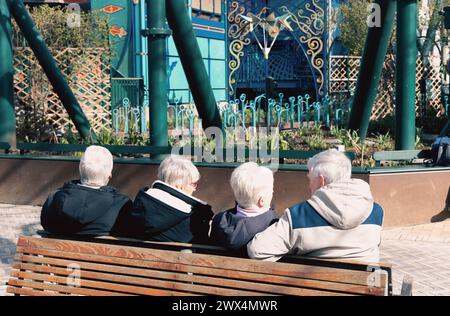 Vier ältere Menschen mit grauem Haar sitzen und entspannen auf einer Bank im Park. Lebensstil im Ruhestand. Stockfoto