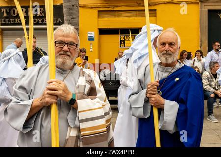 Andalusien, Spanien. Die Osterwoche in Almuneca, Spanien, beginnt mit dem ersten großen Ereignis, dem Palmensonntag (Domingo de Ramos), dem Feiertag, der genau eine Woche vor dem Ostersonntag stattfindet und an Jesu berühmten Einzug auf einem Esel in Jerusalem erinnert. Die Bruderschaften organisieren die Prozessionen, die jeden Tag durch die Straßen und Plätze ziehen, mit wunderschönen "Pasos" und "Tronos", die mit Blumen und religiösen Bildern geschmückt sind, die auf den Schultern der Teilnehmer getragen werden. Auf diesem Bild führen sie die Parade durch die engen Gassen von Almuñécar durch. März 2024 David Smith/Alamy Stockfoto