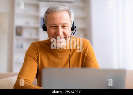 Älterer Mann, der Musik über Kopfhörer genießt Stockfoto