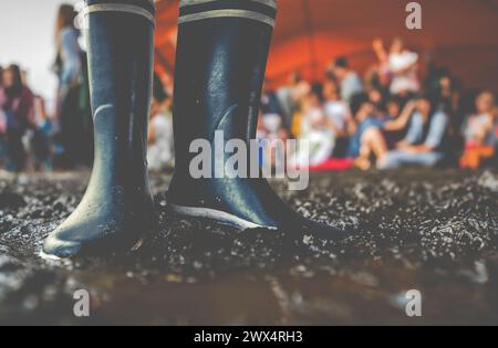 Gummistiefel im Schlamm bei Einem Musikfestival, mit Copy Space Stockfoto