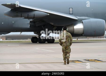 Ein Airman, der der 22nd Aircraft Maintenance Squadron zugewiesen ist, läuft über die Fluglinie, während ein KC-46A Pegasus mit Wing Aerial Betankungspads am 13. März 2024 Taxis in Richtung Start- und Landebahn auf der McConnell Air Force Base in Kansas anbringt. Dies war McConnells erster Testflug mit den POds, mit dem die KC-46 zwei Kampfflugzeuge gleichzeitig betanken konnte. (Foto der U.S. Air Force von Staff Sgt. Tryphena Mayhugh) Stockfoto