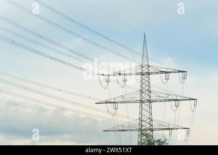 Eine Hochspannungsleitung erhebt sich vor einem klaren blauen Himmel, die Strom über die Landschaft transportiert. Stockfoto