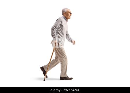 Profilaufnahme eines Reifen Gentlemans, der mit einem Stock auf weißem Hintergrund läuft Stockfoto