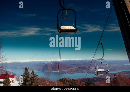 Der Sessellift am blauen Himmel. Eindrucksvoller Blick vom Mottarone Berg (Stresa-Seite) an einem Wintermorgen, nach einem Schneefall. Piemont - Italien. Stockfoto