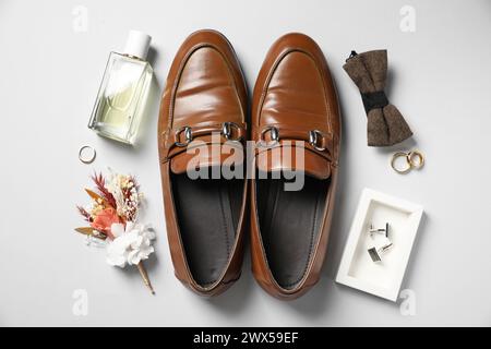 Hochzeitssachen. Flache Komposition mit stilvollem Boutonniere auf hellem Hintergrund Stockfoto