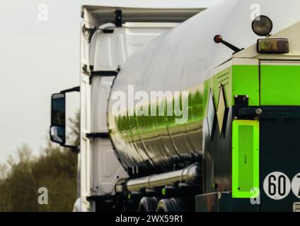 Eine detaillierte Ansicht eines Lkws mit einem riesigen Tanker auf dem Rücken, die Größe und Kapazität des Fahrzeugs betont. Stockfoto