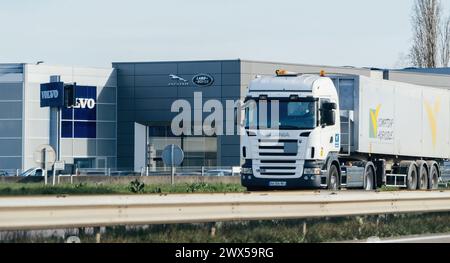 Straßburg, Frankreich - 20. März 2024: In Straßburg, Frankreich, befindet sich ein Jaguar Land Rover Händlerbetrieb in der Nähe eines Volvo One, mit einem Scania-Lkw, der die Vielfalt des Automobilangebots der Stadt erfasst Stockfoto