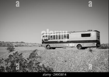 Ein großes Wohnmobil im Busstil, das am Ufer des Lake Havasu geparkt wird. Lake Havasu City, USA. Schwarzweißbild. Stockfoto