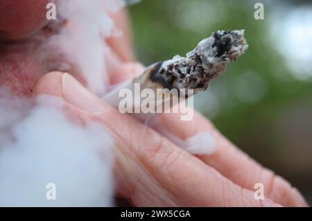 Augsburg, Deutschland. März 2024. Ein Mann raucht einen Joint. Am 22. März hat der Bundesrat den Weg für die teilweise Legalisierung von Cannabis am 1. April frei gemacht. Quelle: Karl-Josef Hildenbrand/dpa/Alamy Live News Stockfoto