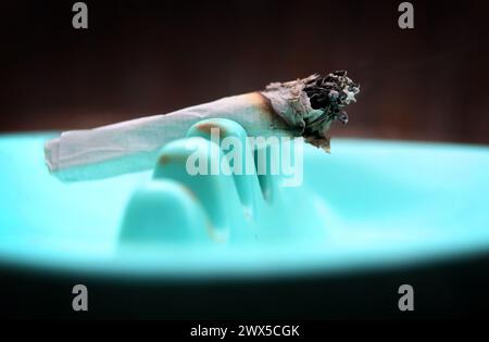 Augsburg, Deutschland. März 2024. Ein Joint klemmt in einem Aschenbecher. Am 22. März hat der Bundesrat den Weg für die teilweise Legalisierung von Cannabis am 1. April frei gemacht. Quelle: Karl-Josef Hildenbrand/dpa/Alamy Live News Stockfoto