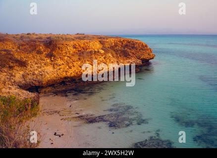 Kleiner Strand umgeben von Korallenvorsprüngen auf Moucha Island am frühen Morgen Stockfoto