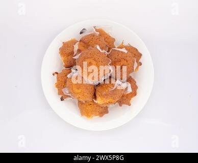 Selbstgebackene einfache Cupcakes in Teller auf weißem isoliertem Hintergrund. Draufsicht. Stockfoto
