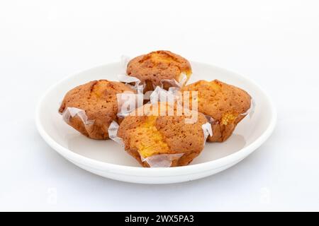 Frische kleine Kuchen in Keramikplatte auf weißem Hintergrund Stockfoto